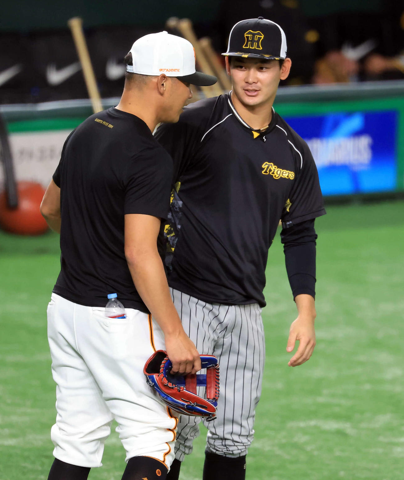 巨人対阪神　試合前、巨人矢野コーチ（手前）にあいさつする阪神野口（撮影・浅見桂子）