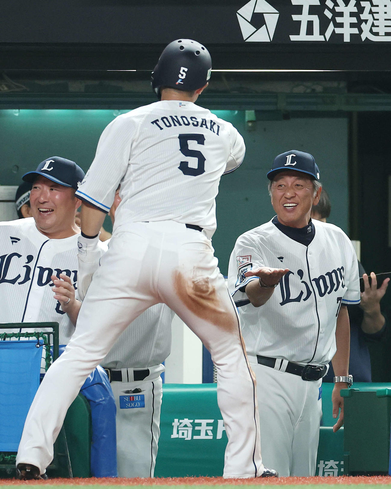西武対オリックス　5回裏西武1死三塁、源田の中犠飛で生還する外崎（手前）を迎える渡辺監督代行（右）（撮影・河田真司）