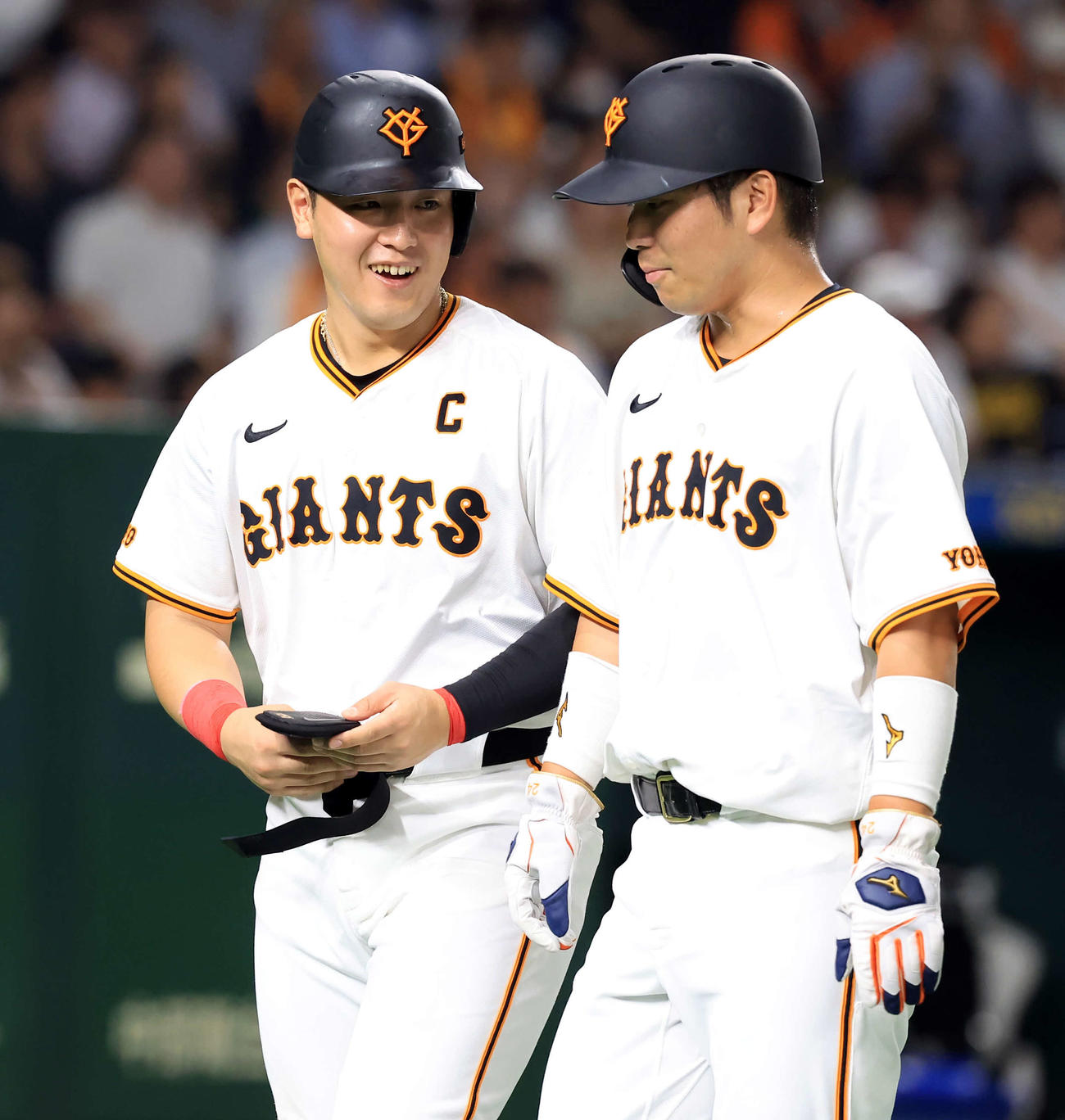 巨人対阪神　1回裏巨人の攻撃で適時打を放った岡本和（左）と大城卓は笑顔でベンチに戻る（撮影・浅見桂子）