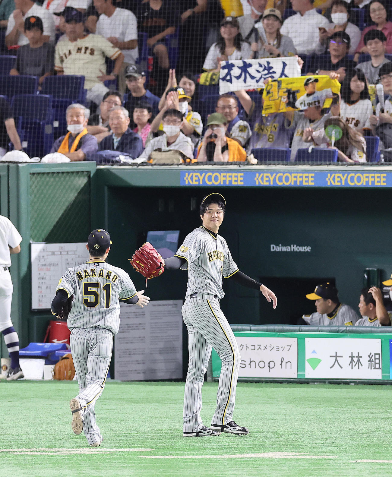 巨人対阪神　8回を2失点で終えた阪神才木（右）は笑顔でタッチを交わす（撮影・足立雅史）