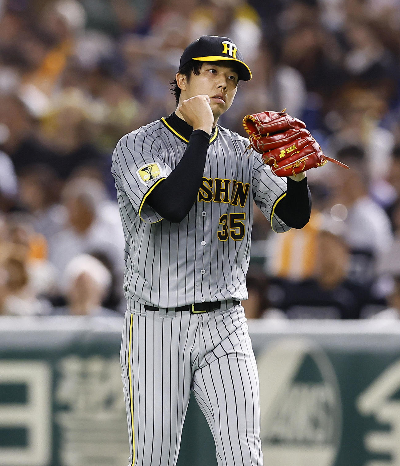 巨人対阪神　7回裏巨人2死二、三塁、岸田を右飛に打ち取りグラブをたたく才木（撮影・藤尾明華）