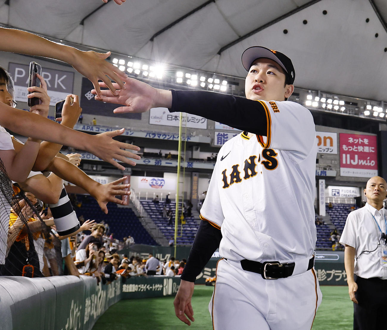 巨人対阪神　ファンとタッチを交わす巨人山崎伊（撮影・藤尾明華）