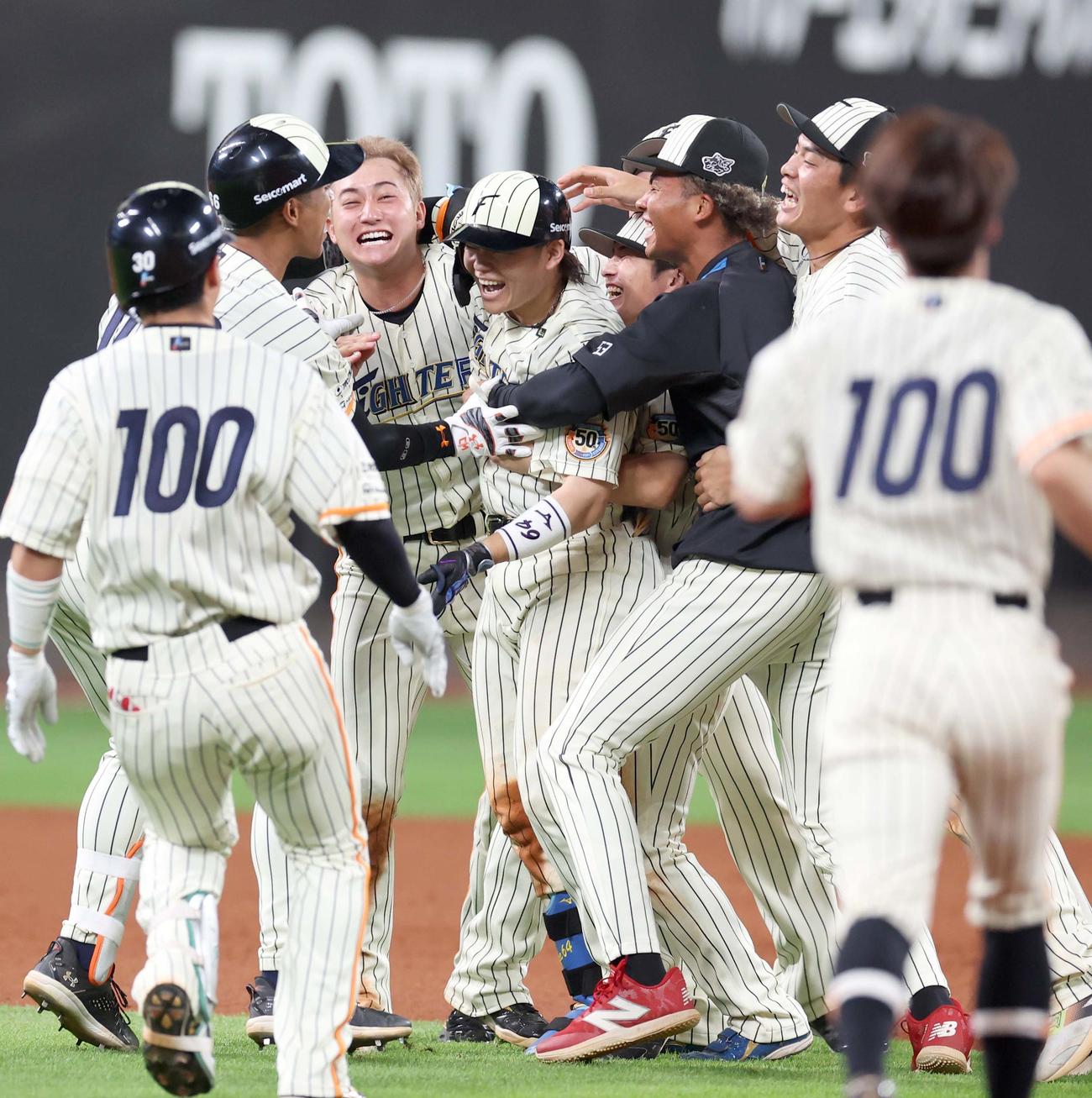 日本ハム対楽天　10回裏日本ハム2死二塁、サヨナラ打を放ち選手と抱き合う田宮（中央）（撮影・黒川智章）
