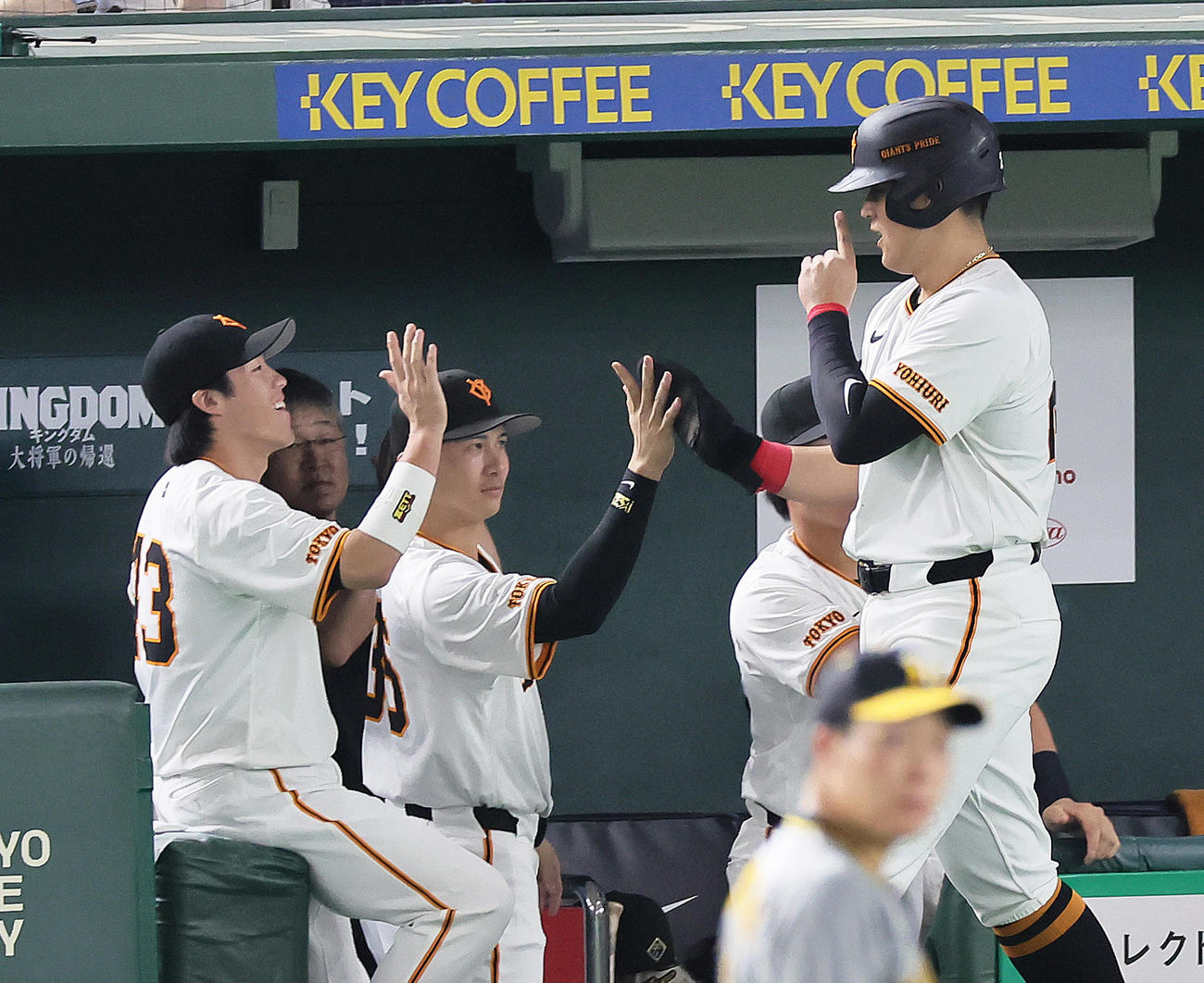 巨人対阪神　4回裏巨人無死二、三塁、坂本勇人の右犠飛で生還した岡本和（右）はポーズをしながらタッチを交わす（撮影・足立雅史）