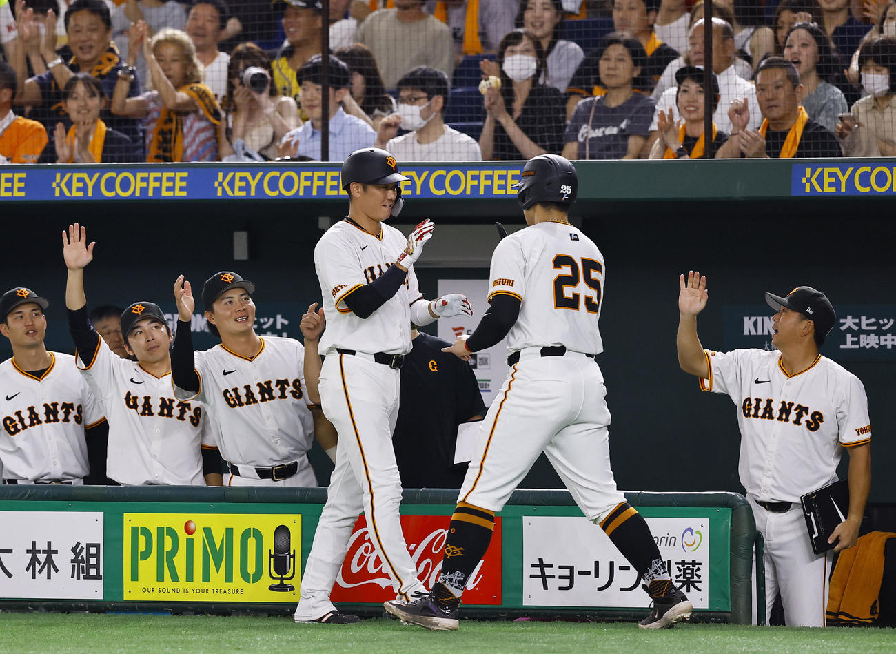 巨人対阪神　4回裏巨人無死二、三塁、右犠飛を放ち、生還した岡本和とタッチを交わす坂本（右から3人目）（撮影・藤尾明華）