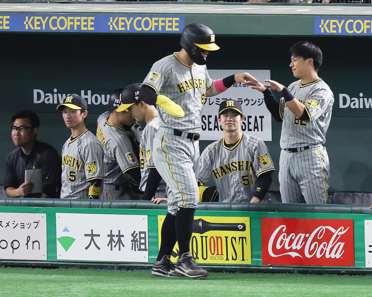 巨人対阪神　2回表阪神無死二塁、大山の先制適時二塁打で生還した佐藤輝（中央）を迎えるナインら。左から2人目は近本、右から2人目は中野（撮影・足立雅史）