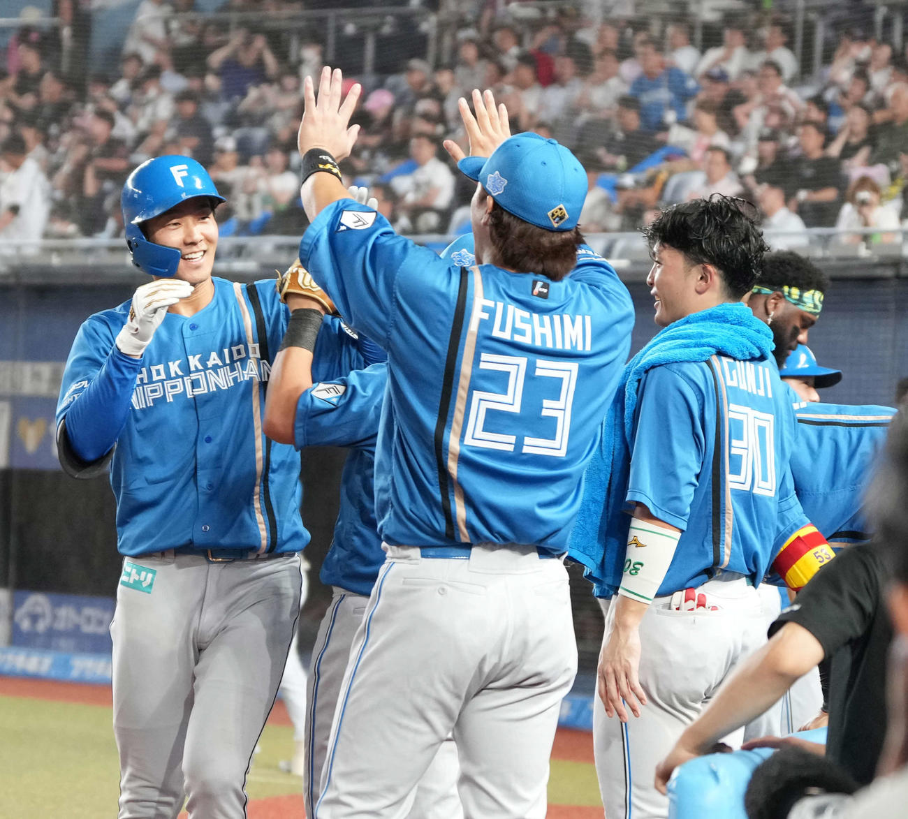 ロッテ対日本ハム　8回表日本ハム無死、石井（左）は右越えに先制ソロ本塁打を放ちベンチのナインの祝福を受ける（撮影・小沢裕）