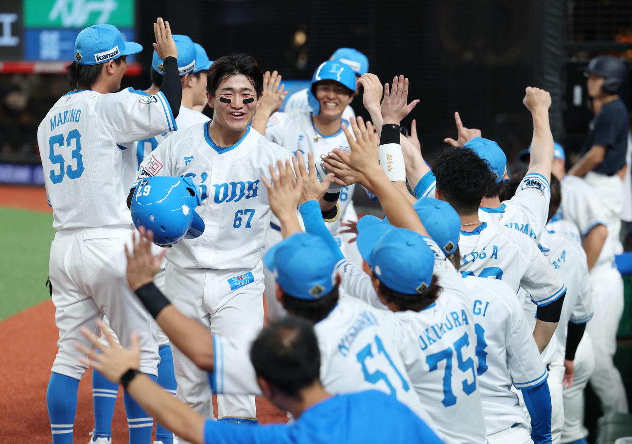 西武対ソフトバンク　1回裏西武1死一、二塁、左越え先制2点本塁打で生還し、チームメートに迎えられる野村大（中央）（撮影・河田真司）