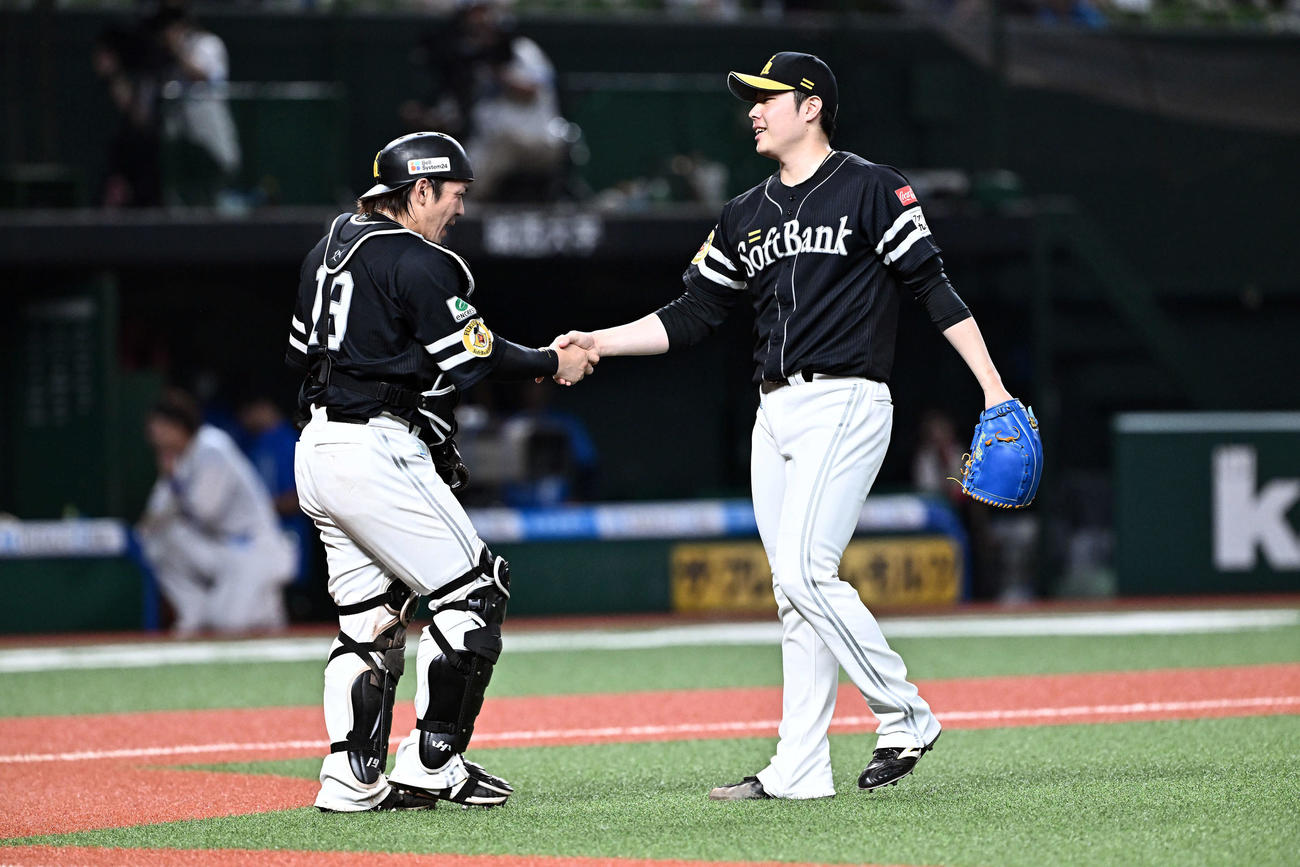 西武対ソフトバンク　9回裏、ソフトバンク2番手で試合を締めた松本裕（右）は甲斐と握手を交わす（撮影・滝沢徹郎）