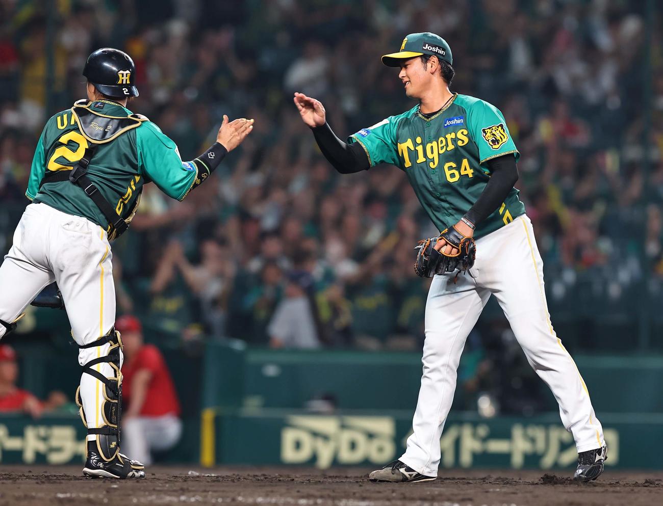 阪神対広島　広島に勝利した岡留（右）は梅野とハイタッチをする（撮影・上田博志）