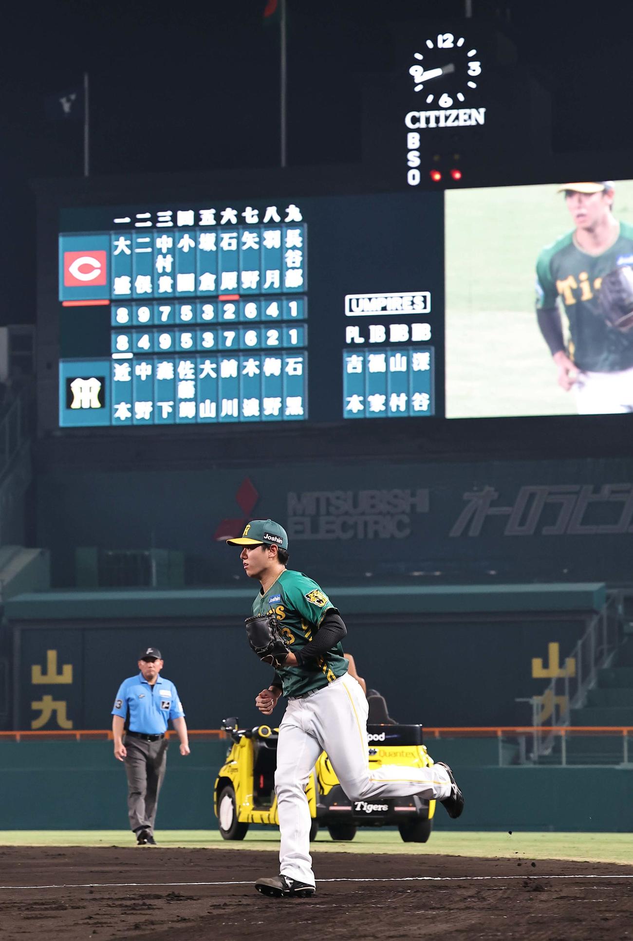 阪神対広島　プロ初登板の石黒は名前の入ったスコアボードを背にマウンドへ向かう（撮影・上田博志）