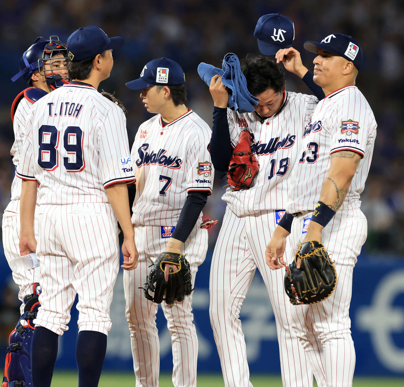 ヤクルト対DeNA 3回表DeNA2死満塁、度会に押し出し死球を与え、マウンドに集まったナインの中で汗をぬぐう奥川（右から2人目）（撮影・浅見桂子）