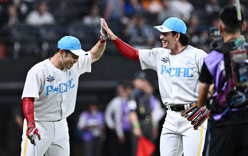 全パ対全セ ホームランダービーの決勝進出を決めた全パ近藤(左)は打撃投手を務めた栗原とタッチをかわす(撮影・滝沢徹郎)