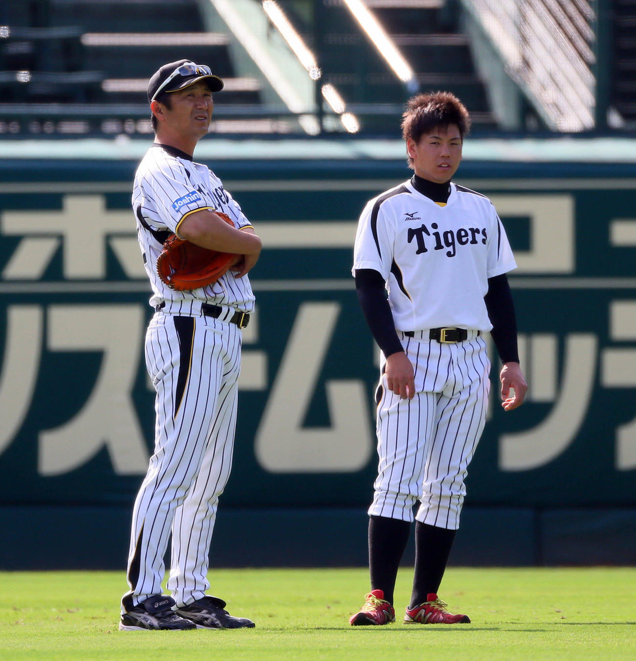 14年9月、甲子園の外野で話し込む阪神梅野（右）と山田コーチ