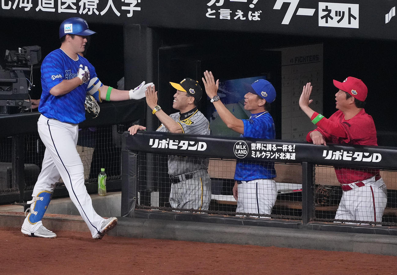 全パ対全セ　4回表全セ無死一塁、左中間に2点本塁打を放った牧（左）は岡田監督（左から2人目）らとタッチを交わす（撮影・鈴木みどり）