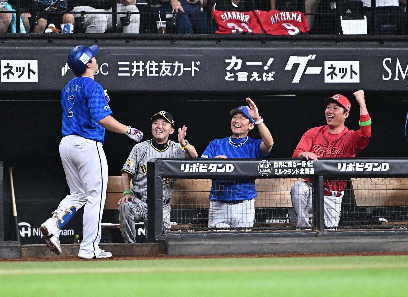 全パ対全セ　2回表全セ2死、ソロ本塁打を放った牧（手前左）を迎える岡田監督（後方左）、三浦コーチ（同中央）、新井コーチ（撮影・滝沢徹郎）