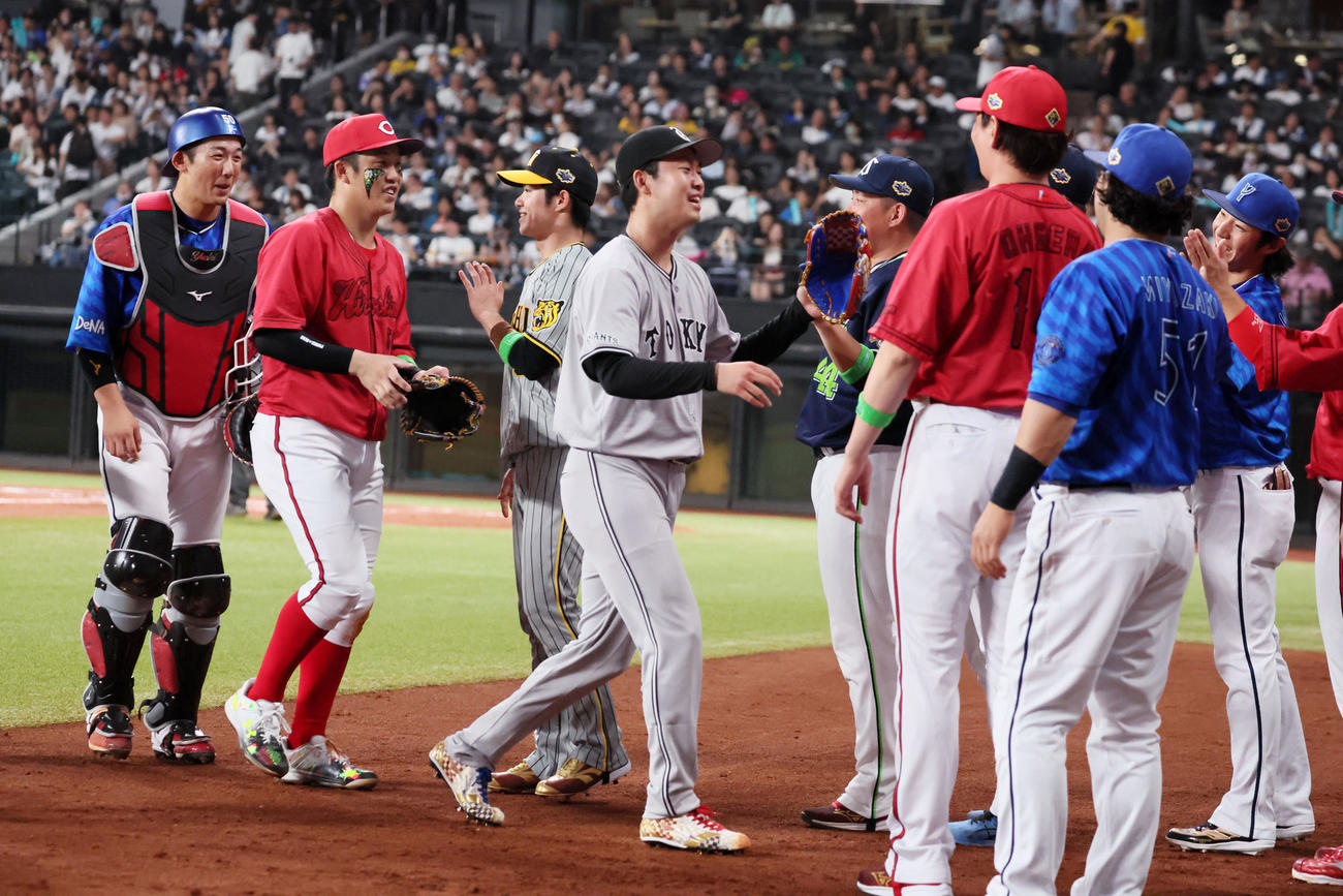 全パ対全セ　4回裏を終え、ベンチ前で出迎える全セの選手らとタッチを交わす巨人山崎伊（中央）（撮影・加藤哉）