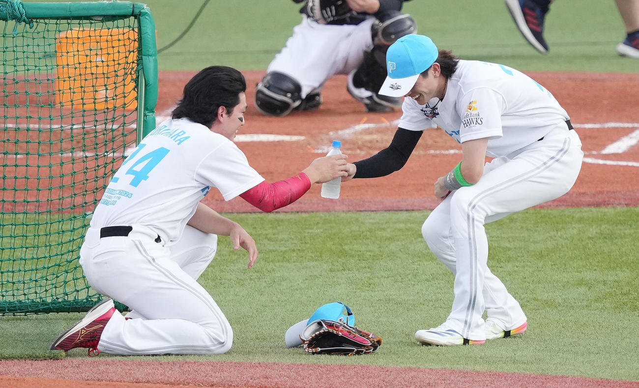 全セ対全パ　ホームランダービー決勝で山川と近藤が延長戦となり、両選手の打撃投手を務める栗原（左）は周東から水を受け取る（撮影・鈴木みどり）
