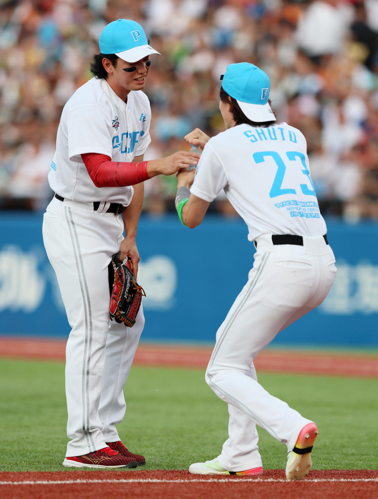 全セ対全パ　ホームランダービー決勝で近藤と山川相手に打撃投手を務める栗原は水を要求、素早く周東（右）が渡す好プレー（撮影・加藤哉）
