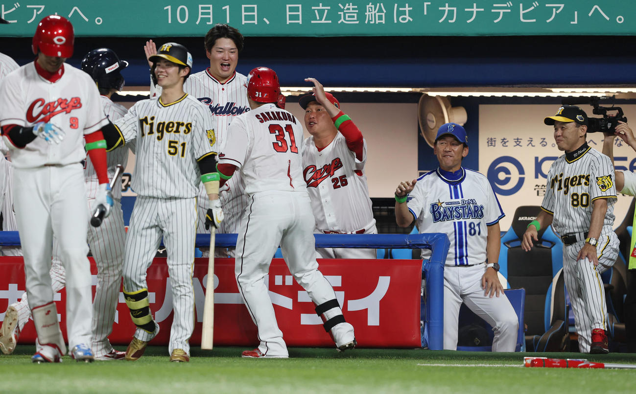 全セ対全パ　2回裏全セ2死満塁、坂倉は中越え満塁本塁打を放ち新井コーチ（中央右）からヘルメットを叩かれ祝福される（撮影・加藤哉）