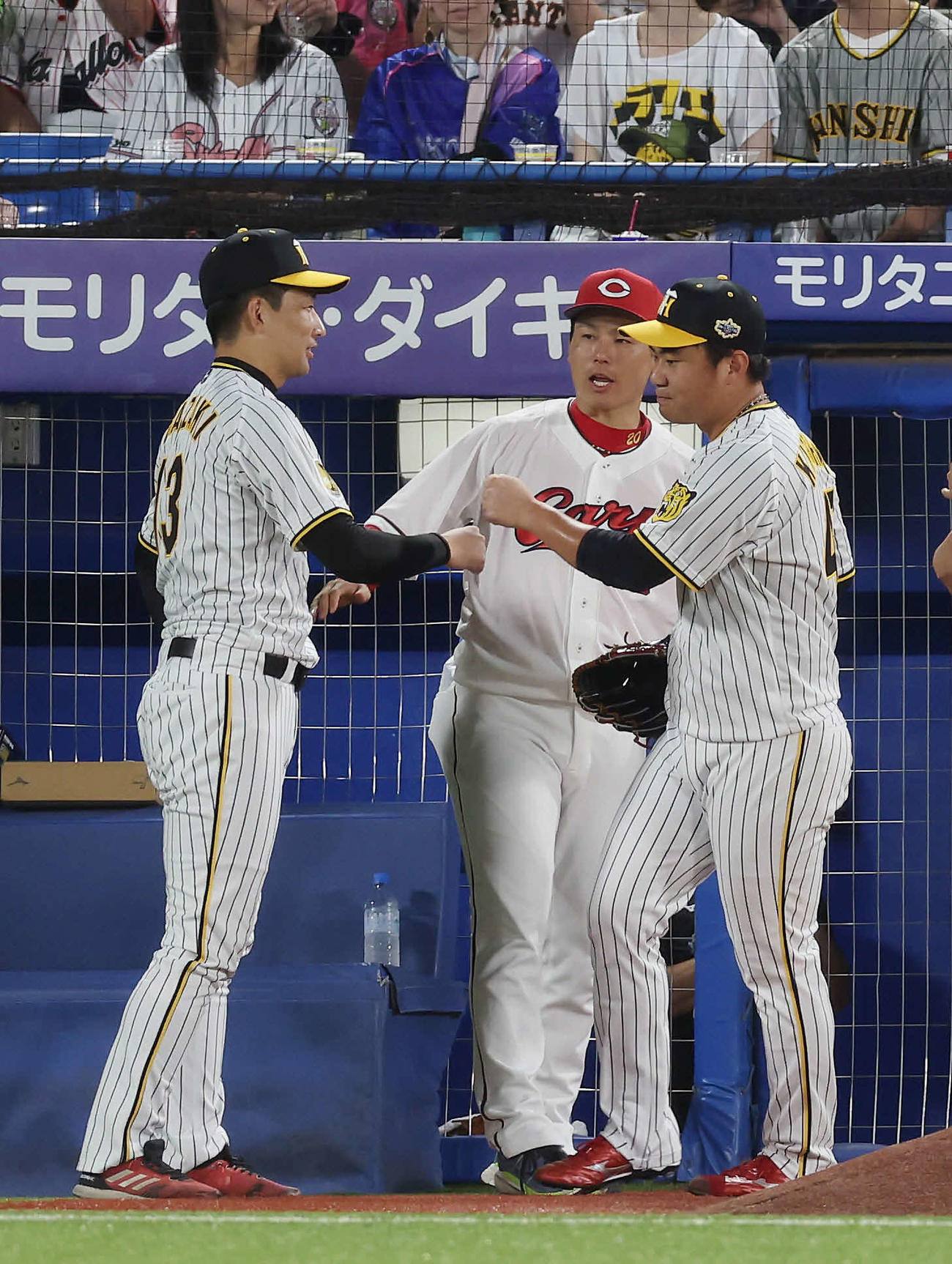 全セ対全パ　7回表のマウンドに向かう阪神桐敷（右）を送り出す岩崎。中央は広島栗林（撮影・前田充）