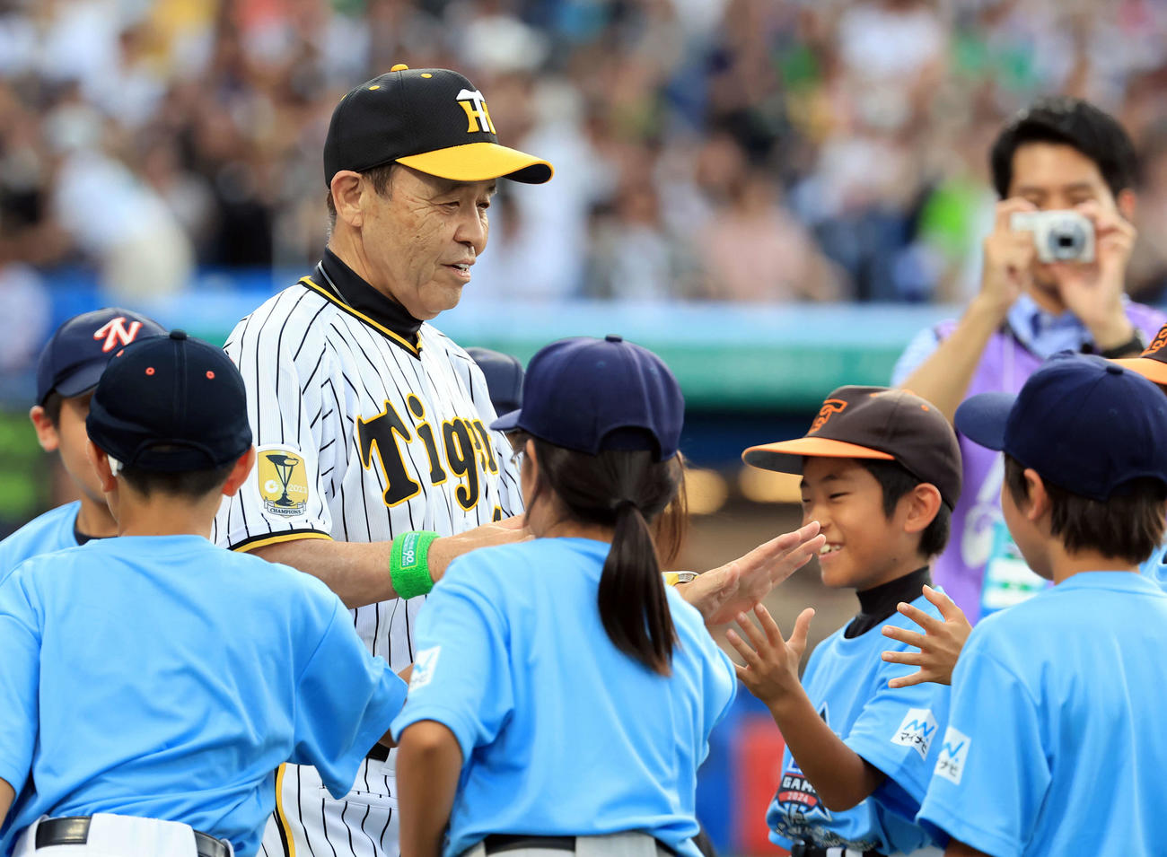 全セ対全パ　入場時、笑顔で子どもとハイタッチする阪神岡田監督（撮影・浅見桂子）
