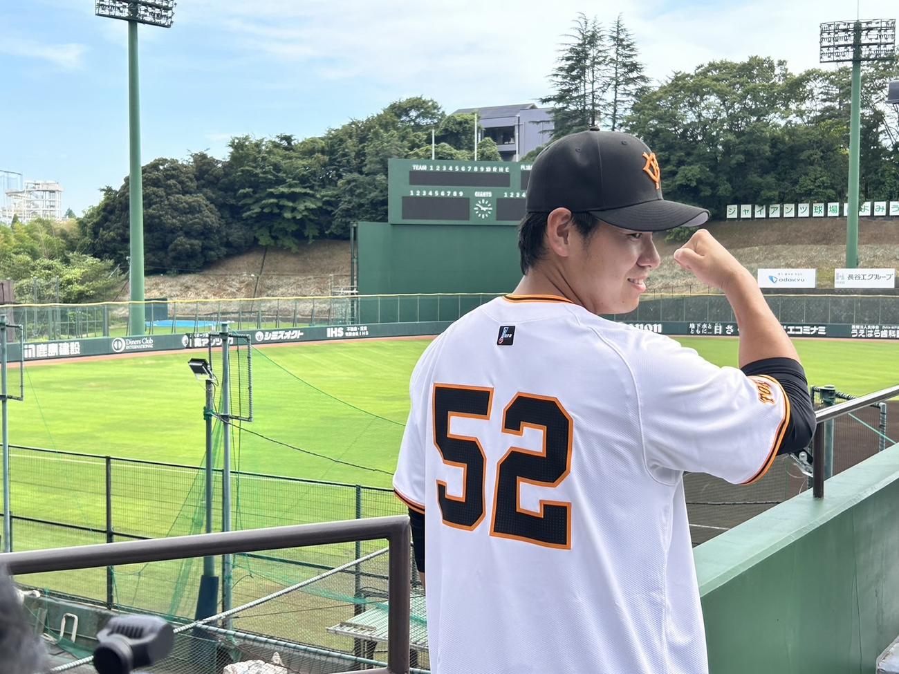 背番号52のユニホームに袖を通し、笑顔の巨人伊藤（撮影・上田悠太）
