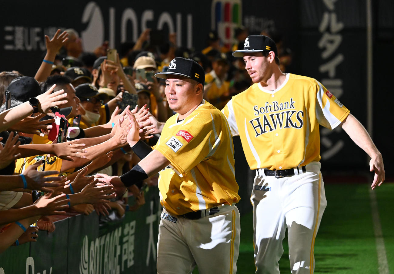 ソフトバンク対オリックス　ファンとタッチを交わす左から山川とスチュワート（撮影・林敢治）