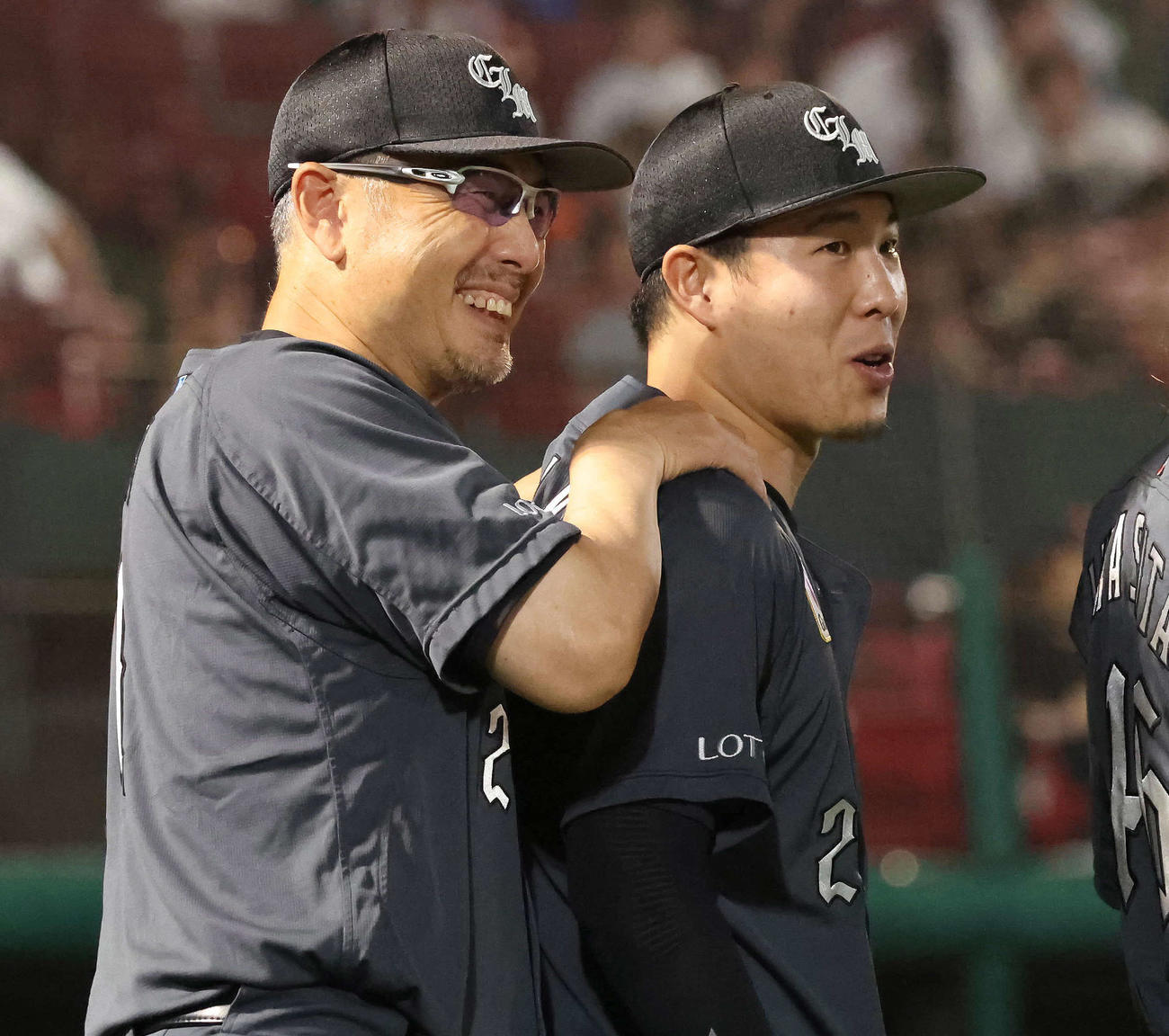 楽天対ロッテ　勝利投手の西野（右）の肩を笑顔でもむロッテ吉井監督（撮影・丹羽敏通）