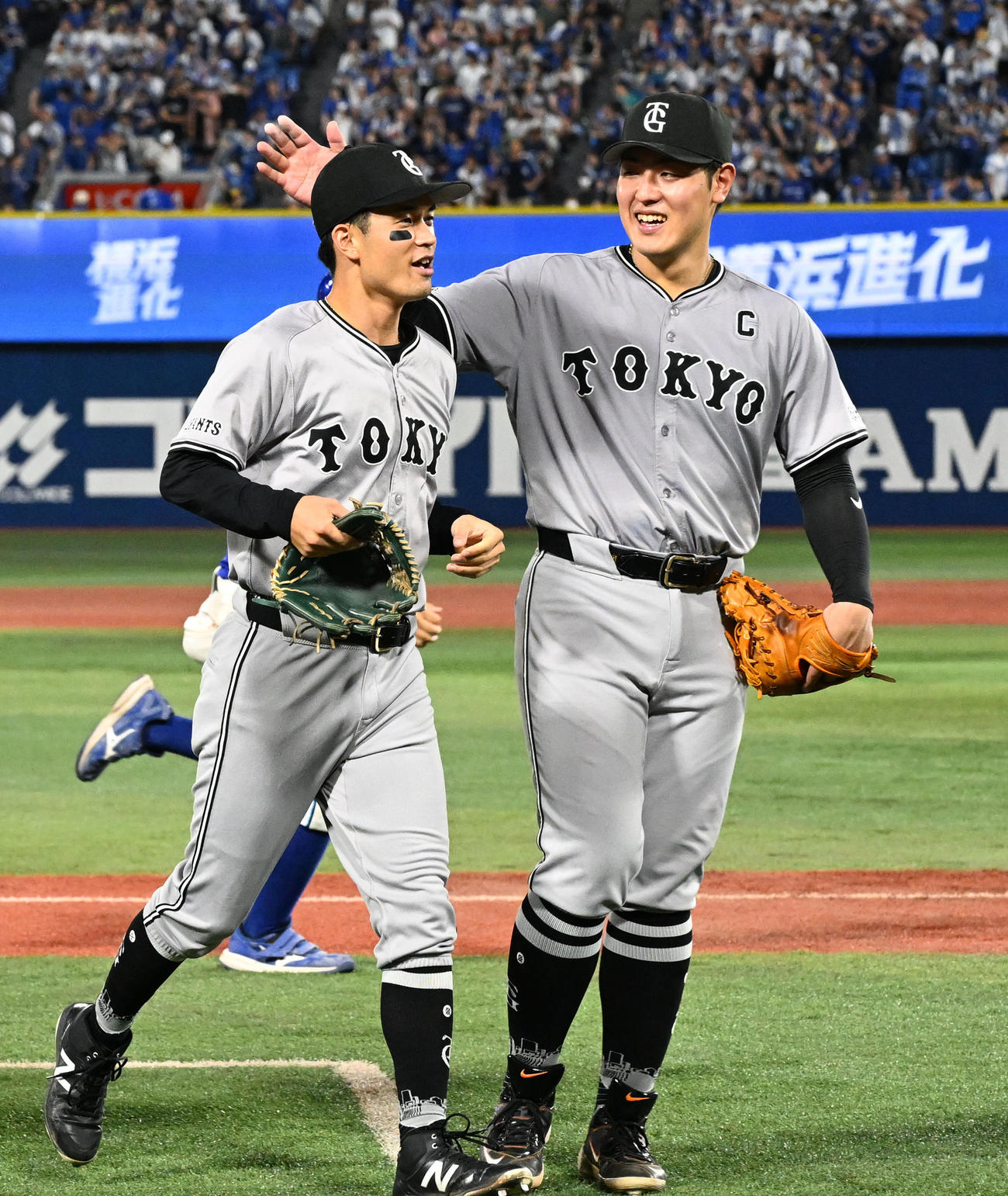 DeNA対巨人　8回裏DeNA2死、牧秀悟の左飛を好捕した若林（左）を迎える岡本和（撮影・千葉一成）