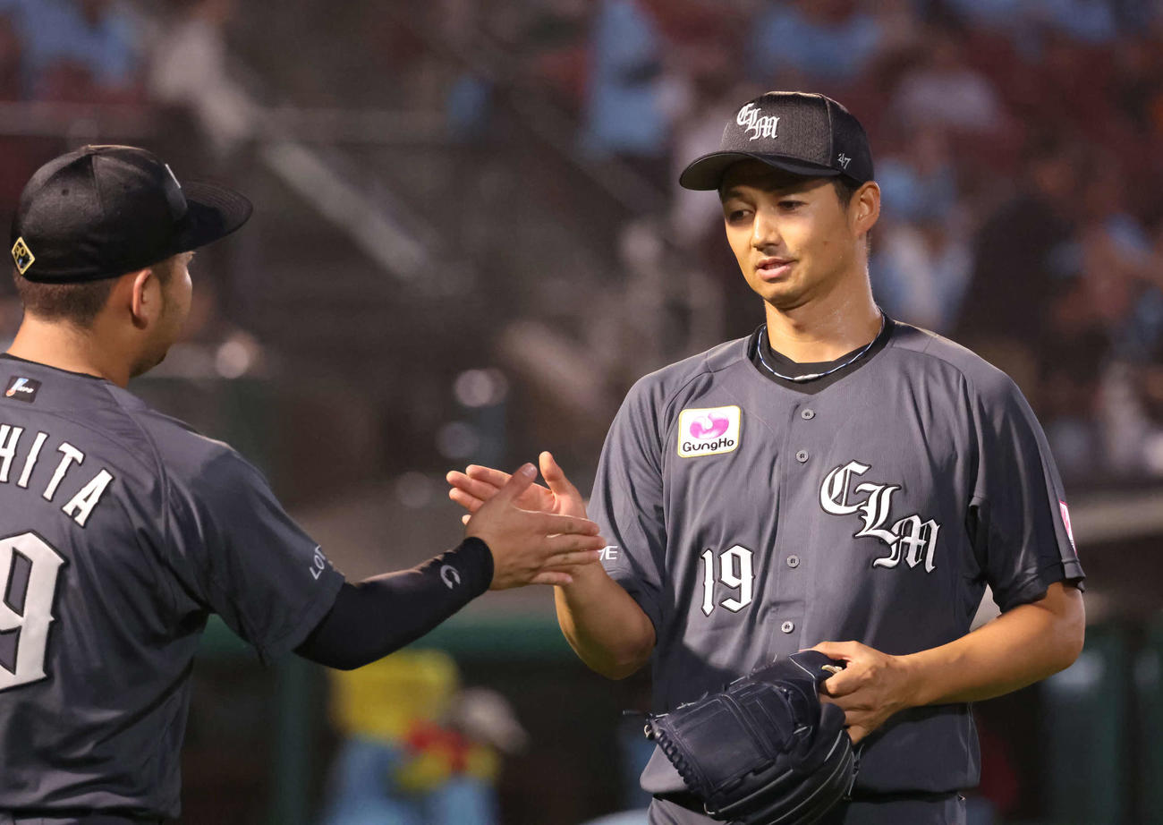 楽天対ロッテ　3回を終えて、チームメートにタッチで迎えられるロッテ先発唐川（撮影・丹羽敏通）