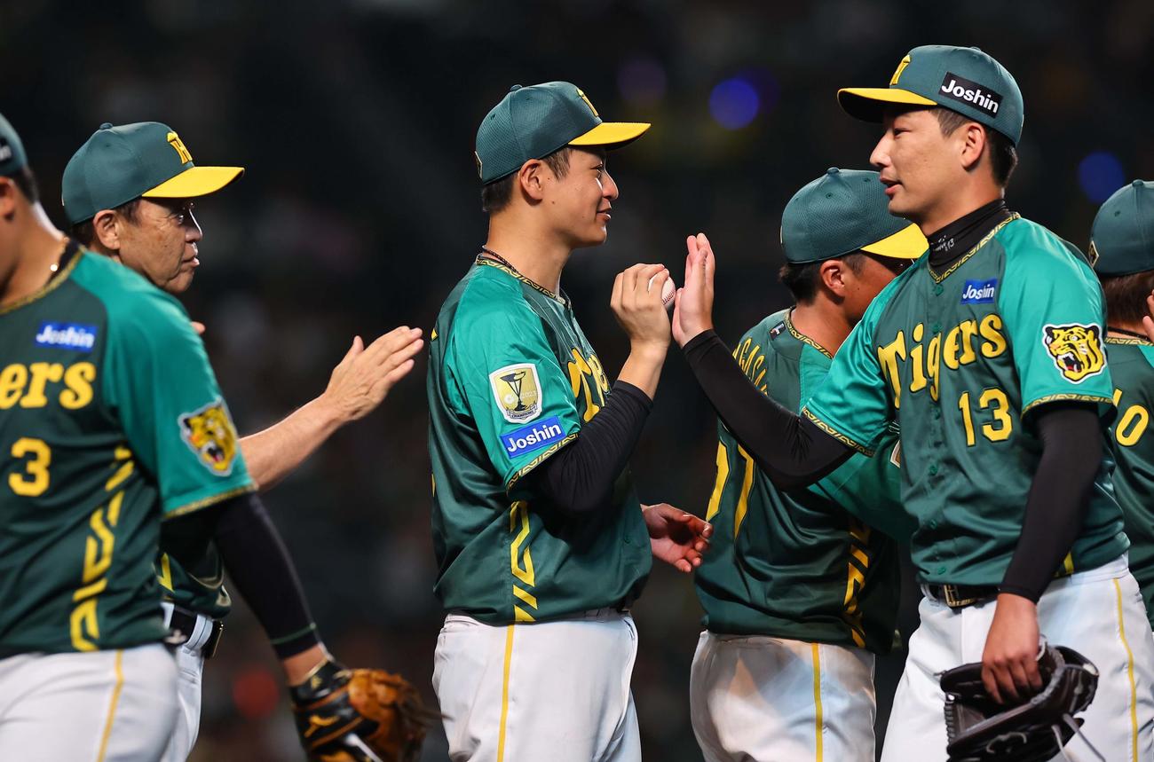 阪神対中日　今季7勝目をあげた大竹（中央）は岩崎（右）から勝利球を受け取る（撮影・上田博志）