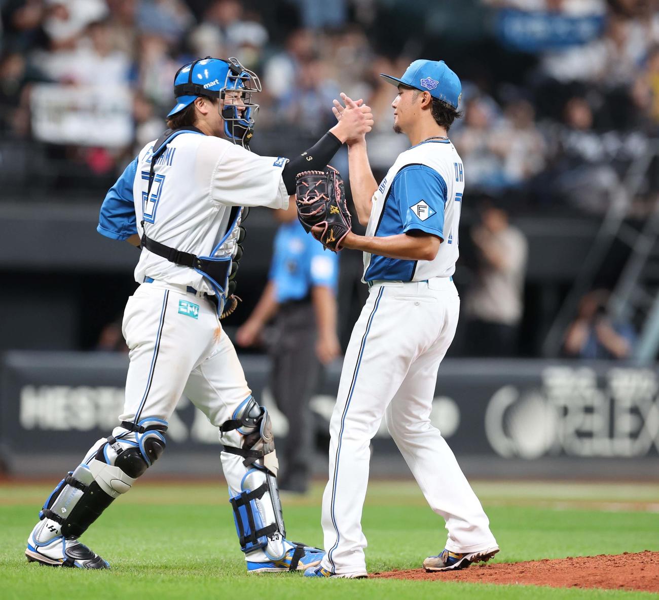 日本ハム対西武　今季2度目のマダックスで8勝目を挙げ伏見とタッチする伊藤（撮影・黒川智章）