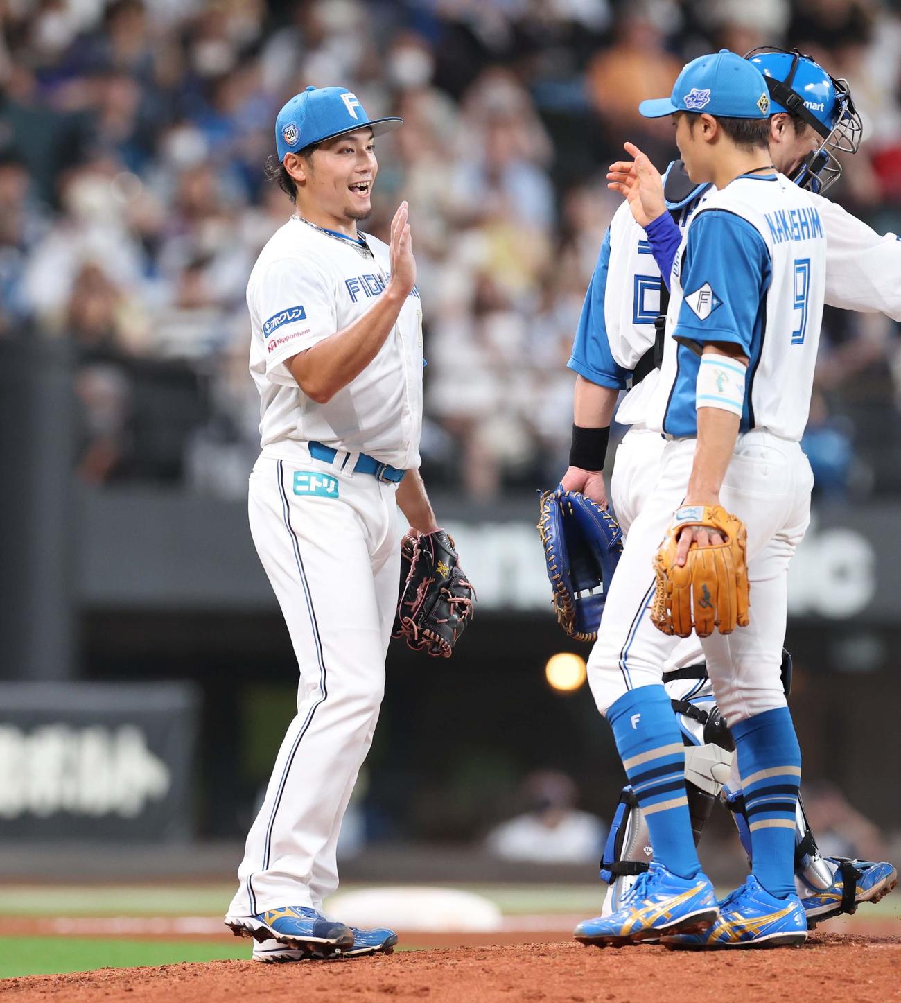 日本ハム対西武　今季2度目のマダックスで8勝目を挙げナインとタッチする伊藤（撮影・黒川智章）