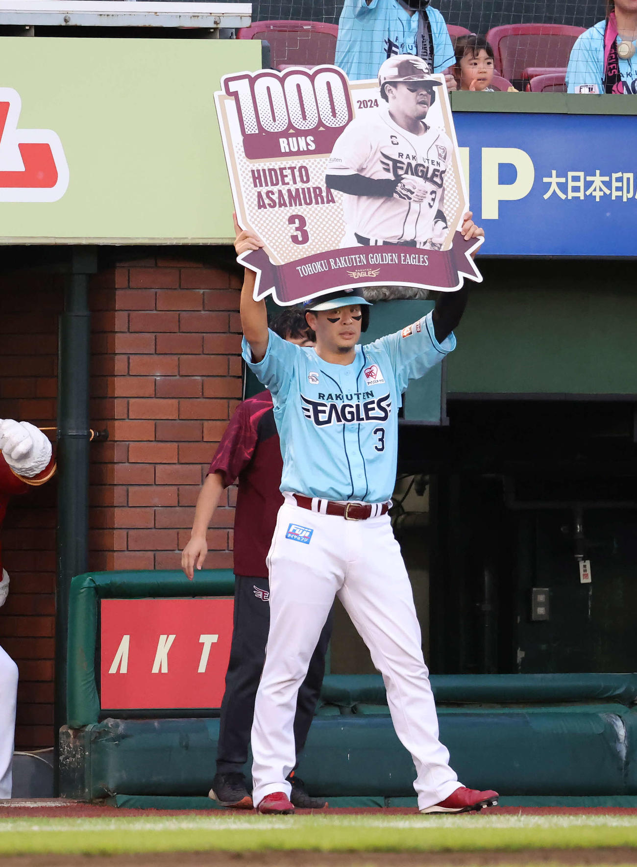 楽天対ロッテ　6回裏楽天1死満塁、村林の右犠飛で生還して1000得点を達成してボードを掲げる浅村（撮影・丹羽敏通）