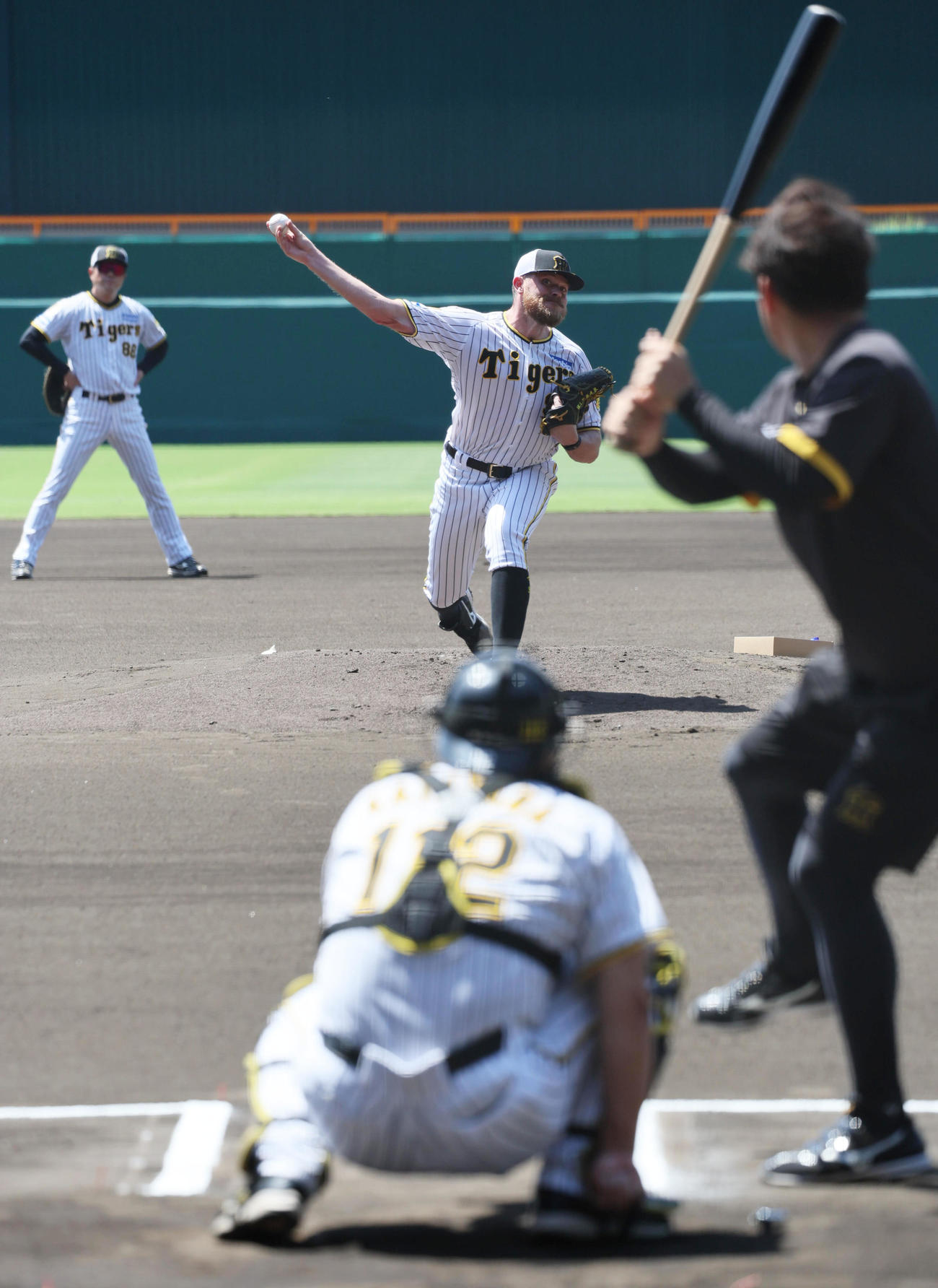 マウンドから投球練習する阪神ビーズリー。左後方は安藤コーチ（撮影・宮崎幸一）