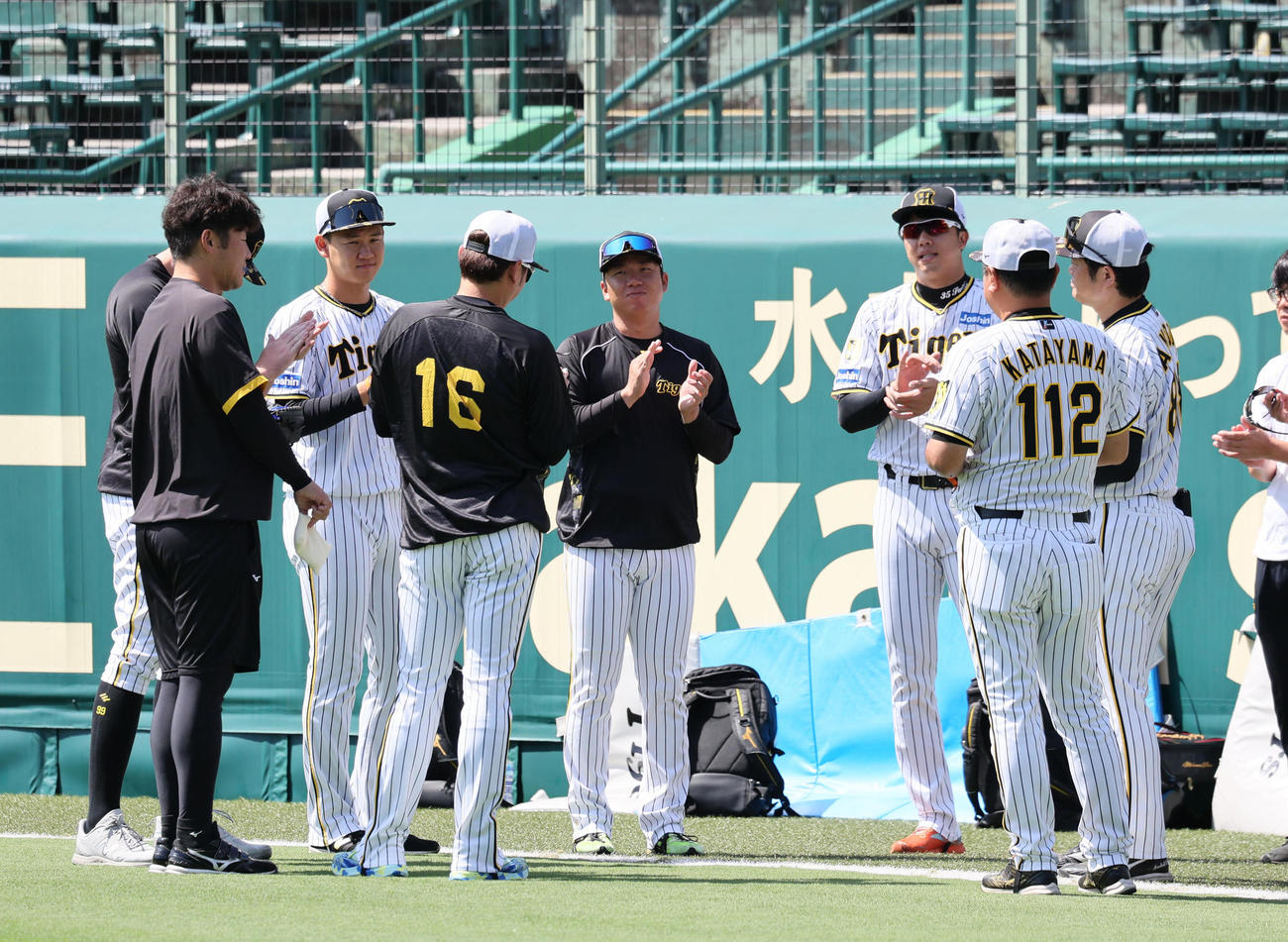 練習前の円陣で拍手する投手陣。左影からビーズリー、1人おいて及川、西勇、村上、才木、1人おいて安藤コーチ（撮影・宮崎幸一）