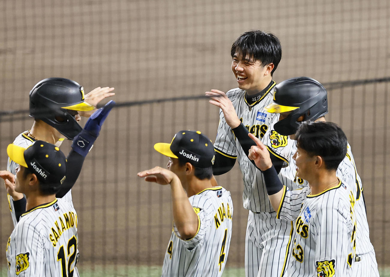 阪神対巨人　6回裏阪神無死一、二塁、大山の左越え3点本塁打に笑顔で前川らを出迎える才木（右から3人目）（撮影・藤尾明華）