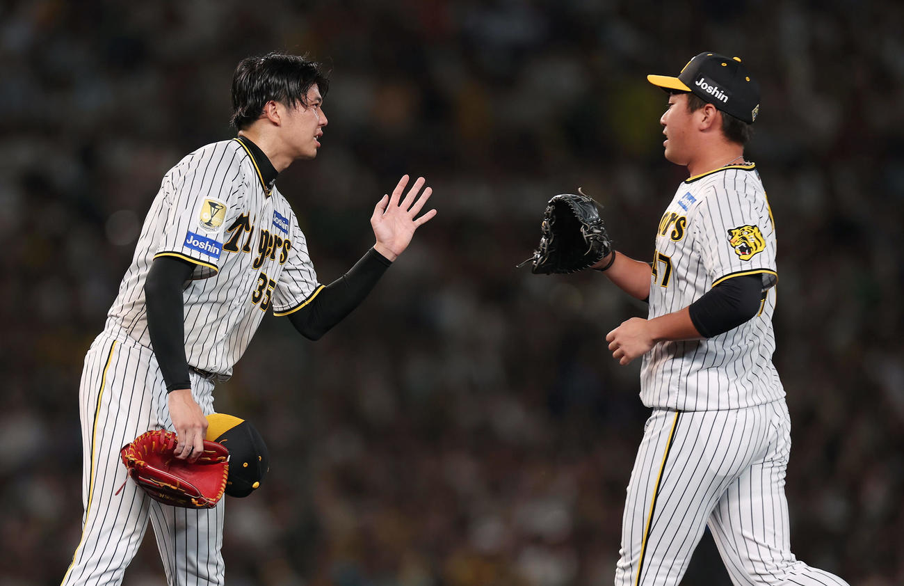 阪神対巨人　7回表巨人1死満塁、打者丸を迎えたところで降板となり、交代する桐敷（右）とタッチを交わす才木（撮影・前田充）