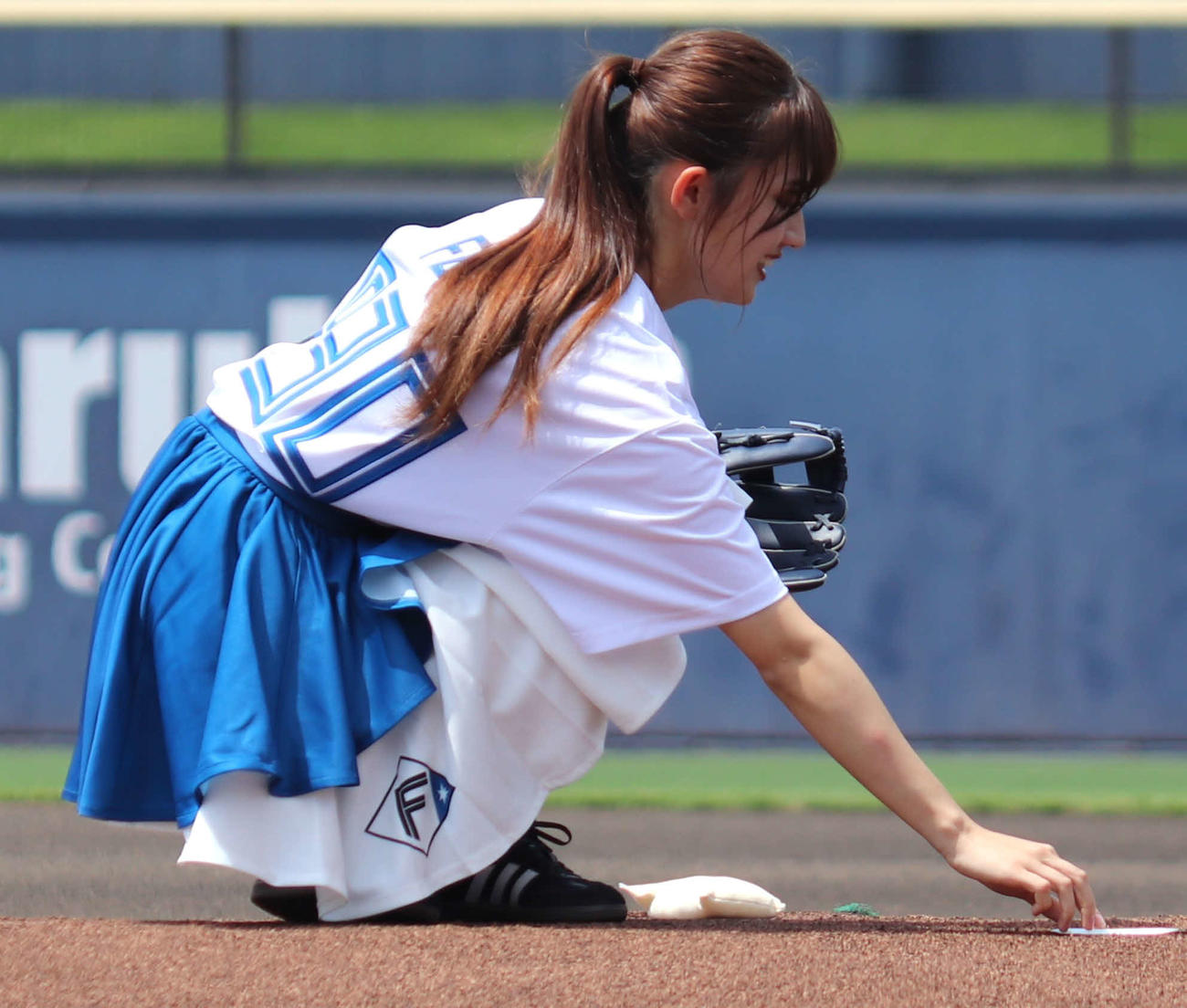 イースタン・リーグ：日本ハム対ロッテ　始球式直前、グラブからはがれたシールを拾うグラビアアイドルの花咲楓香（撮影・黒須亮）