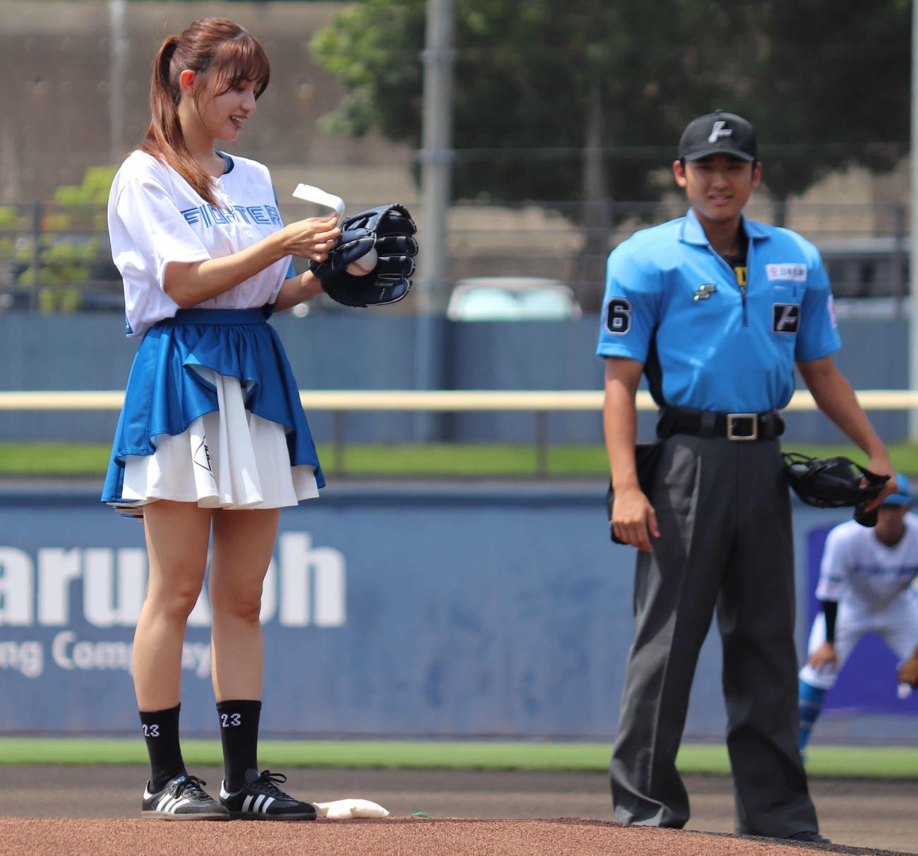 イースタン・リーグ：日本ハム対ロッテ　始球式直前、グラブからはがれたシールを貼り直すグラビアアイドルの花咲楓香（左）（撮影・黒須亮）