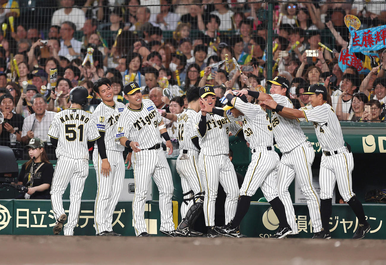阪神隊巨人　6回裏阪神2死二、三塁、佐藤輝の右前適時打で生還した糸原（右から3人目）は手荒い祝福を受ける（撮影・足立雅史）