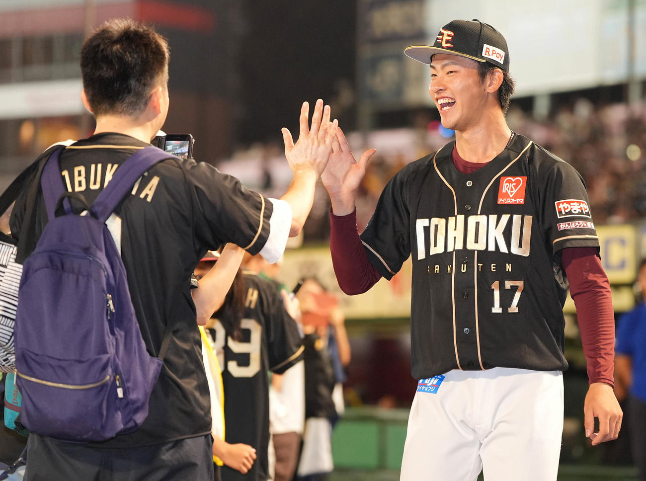 楽天対ソフトバンク　ソフトバンクに勝利し、笑顔でファンとハイタッチする楽天古謝（撮影・鈴木みどり）