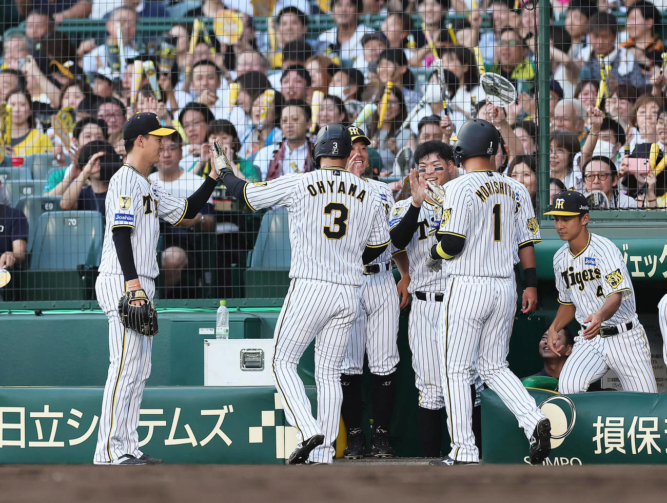 阪神隊巨人　1回裏阪神2死満塁、木浪の2点適時打で生還した大山（中央）と森下（右）をタッチで迎える及川（撮影・足立雅史）
