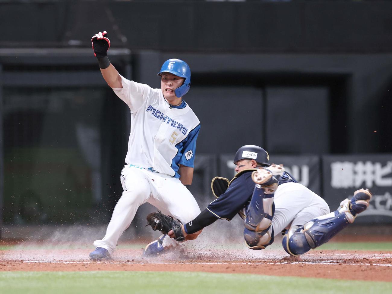 日本ハム対オリックス　4回裏日本ハム1死二、三塁、伏見の右前2点適時打で生還する二塁走者の野村（撮影・黒川智章）