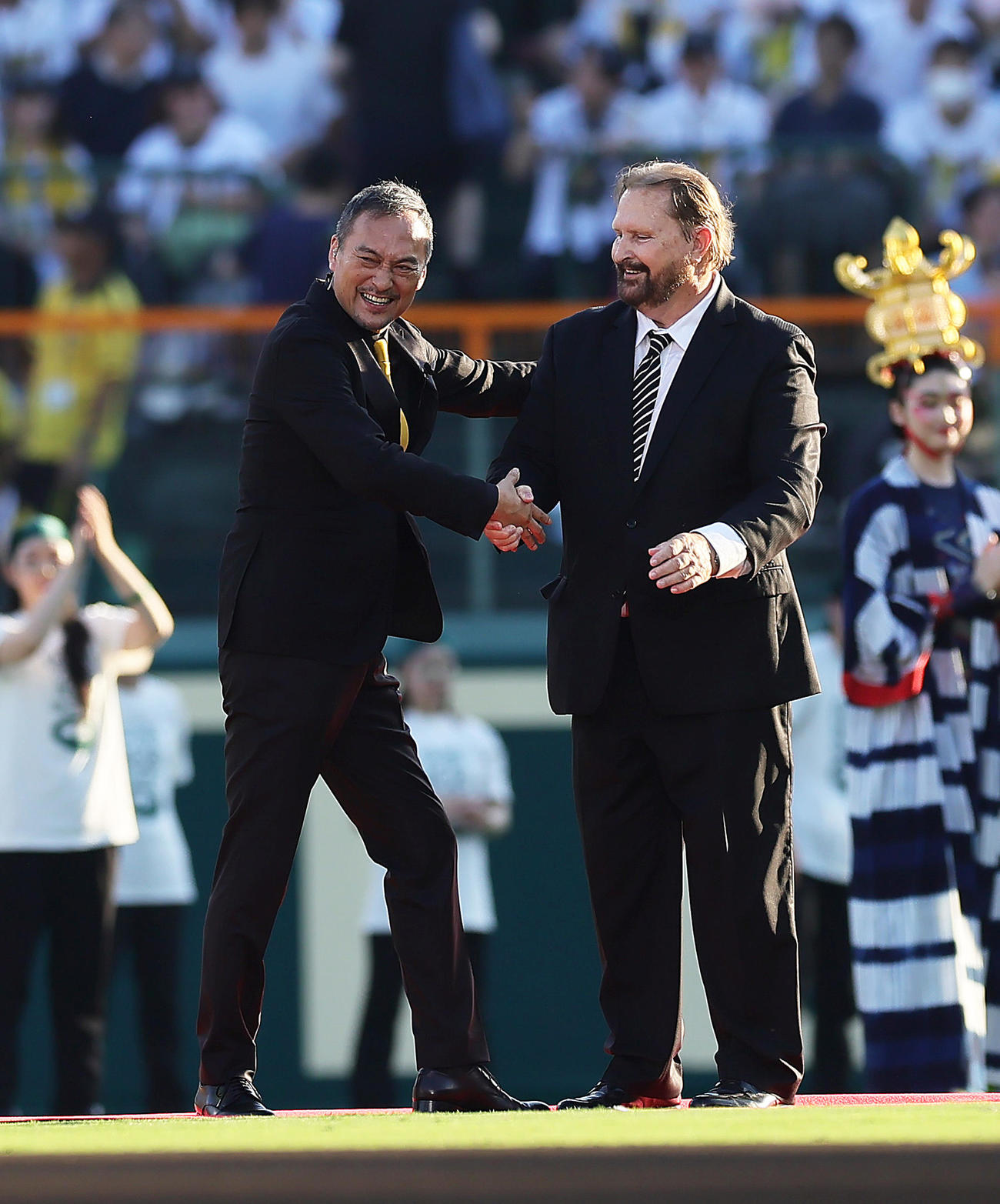 甲子園開場100周年記念式典に登場し握手を交わす渡辺謙（左）とバース氏（撮影・足立雅史）