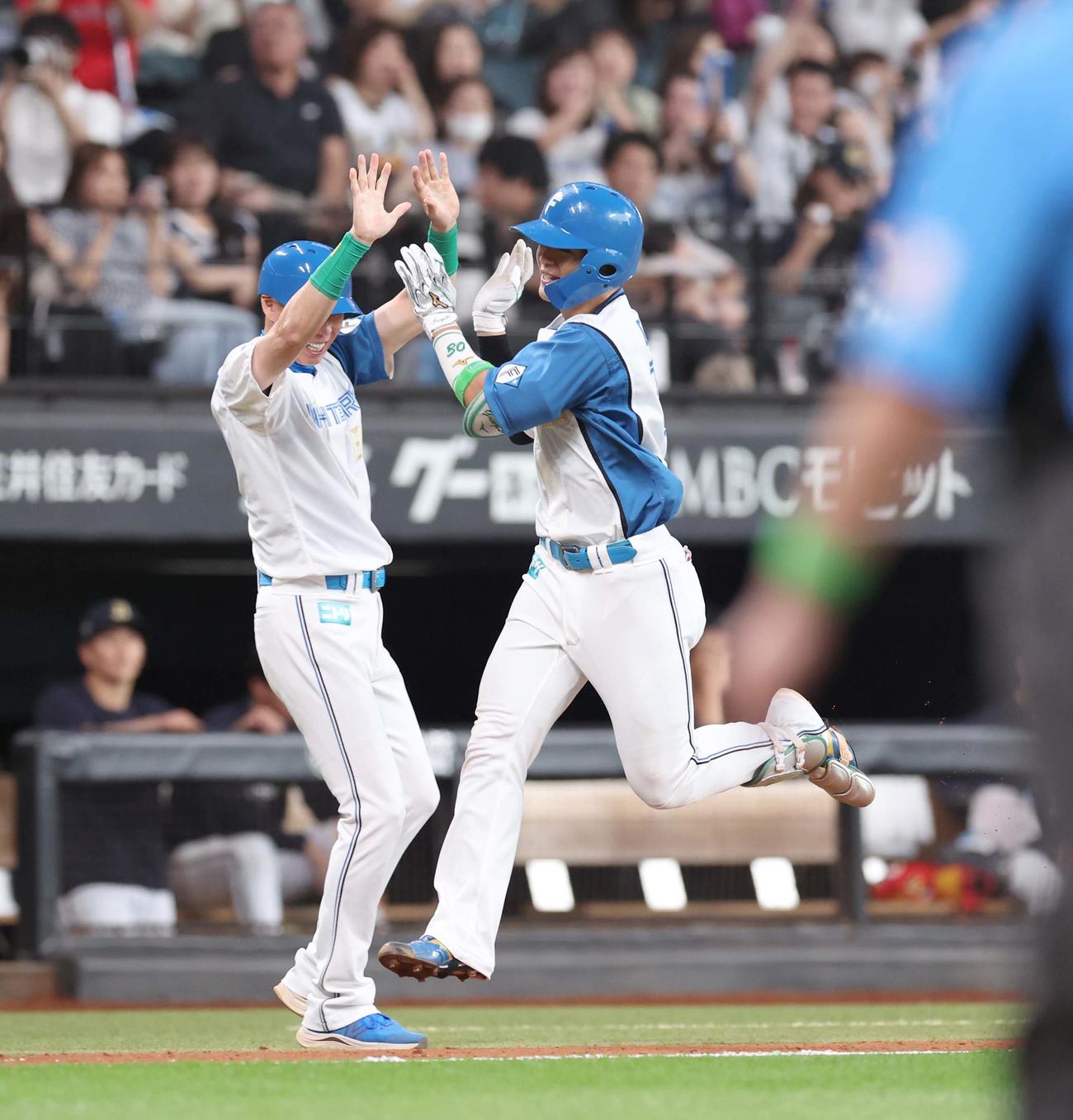 日本ハム対オリックス　9回裏日本ハム1死、左中間にサヨナラ本塁打を放ち森本コーチとハイタッチする郡司（撮影・黒川智章）