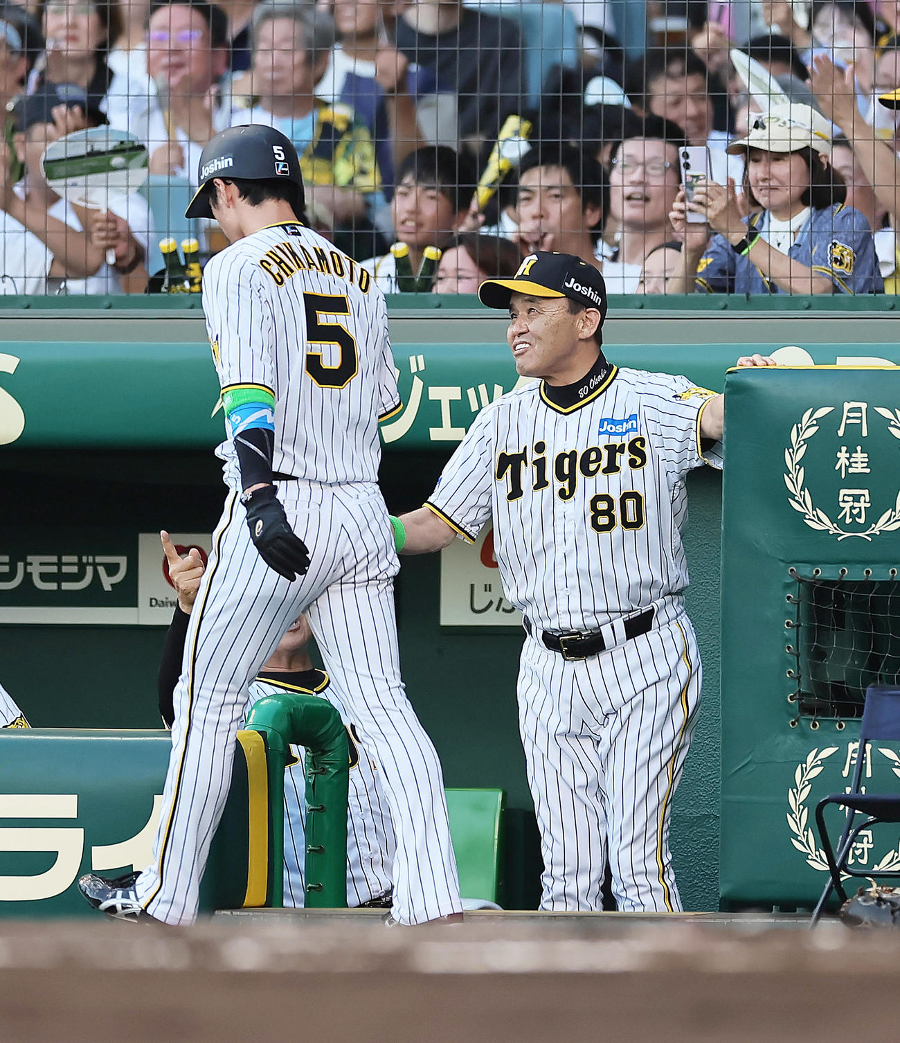 阪神対巨人　1回裏阪神2死満塁、前川の右前2点適時打で生還した近本（左）を笑顔で迎える岡田監督（撮影・足立雅史）