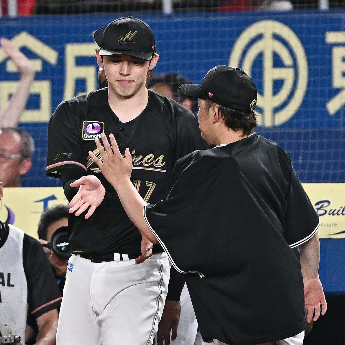 ロッテ対西武　勝利を飾りロッテ佐々木（左）は鈴木とタッチをかわす（撮影・滝沢徹郎）
