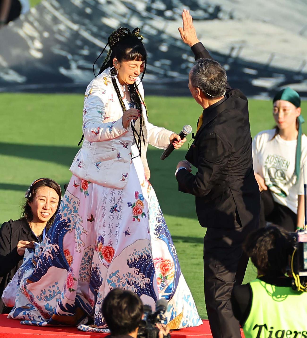 阪神対巨人　名前を間違えたAI（左）の頭をたたくふりをする渡辺謙（撮影・上田博志）
